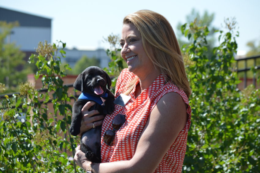 Centennial Mayor Stephanie Piko holding Riley, a school therapy dog, on Sept. 12 at Arapahoe County Sheriff’s Office K-9 training field.